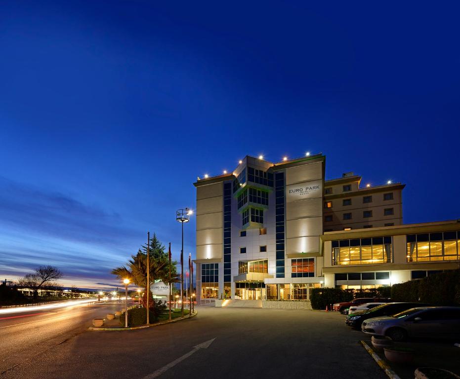 a building at night with cars parked in a parking lot at Euro Park Hotel Bursa Spa & Convention Center in Bursa