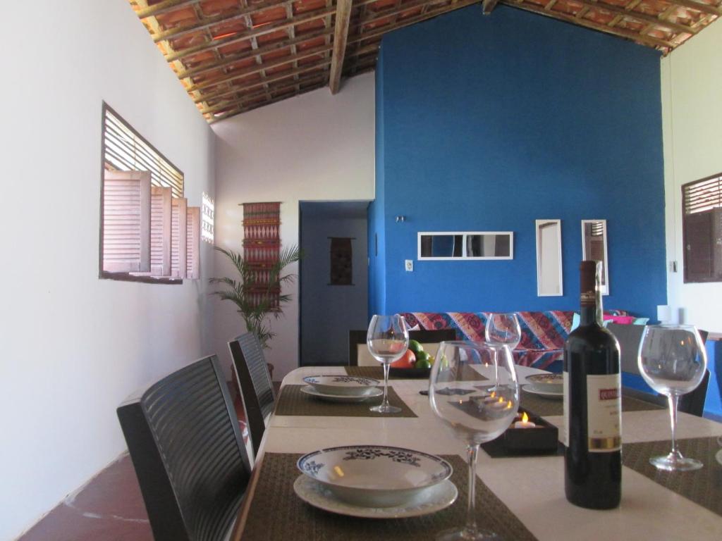 a dining room with a table with a bottle of wine at Natal Casa de Playa en Pitangui‏ in Pitangui