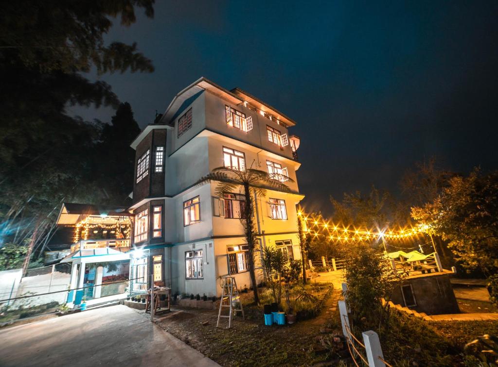 a tall building with lights on it at night at Tag Along 2 0 Hostel Gangtok in Gangtok