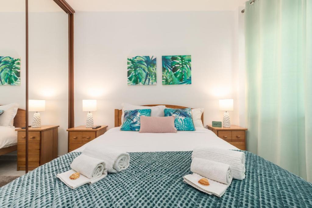 1 dormitorio con 1 cama grande y 2 toallas. en Aquazul Beach Flat - Praia da Rocha en Portimão