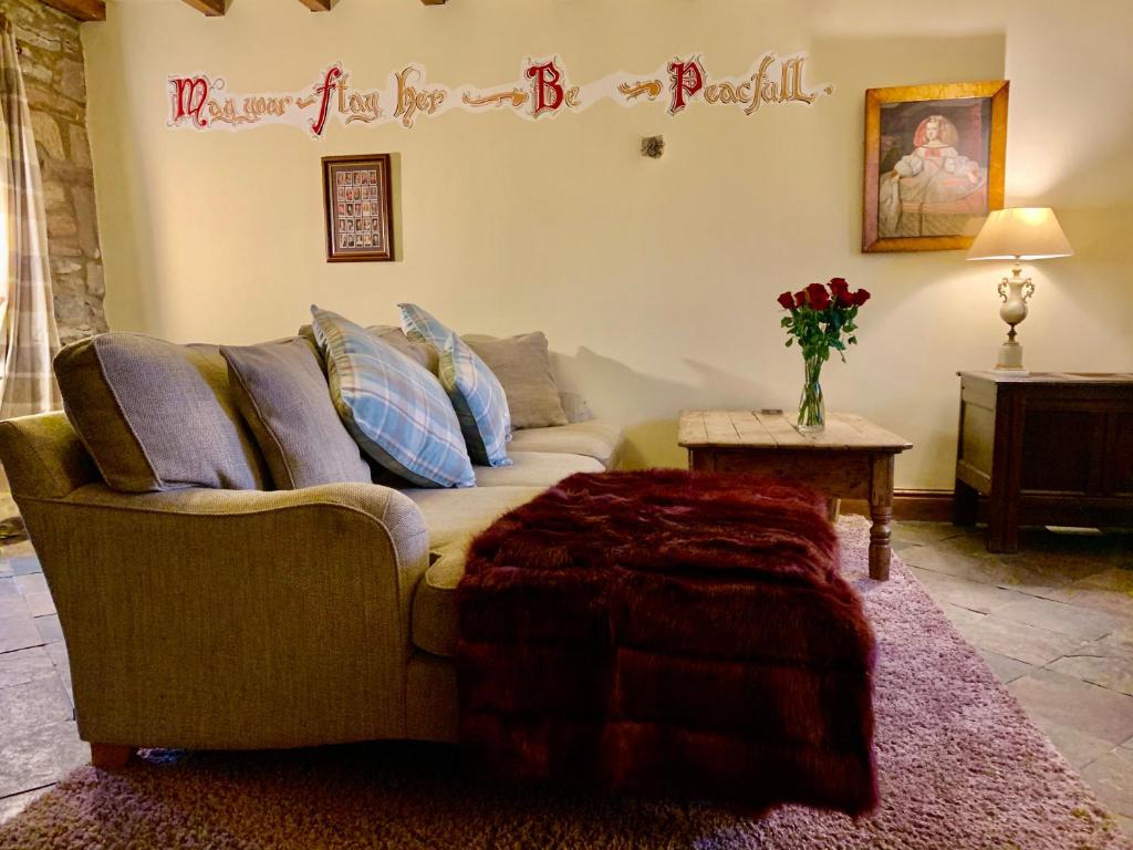 una sala de estar con sofá y una pancarta de feliz cumpleaños en Derbyshire Cottage for 4, 1 hour per day private pool use en Stanton in Peak