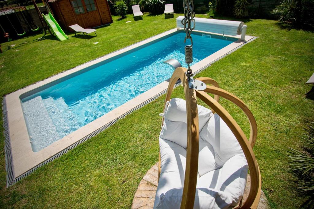 un columpio en un patio junto a una piscina en Gîte de Léonie Moulin de Tartay en Avignon, en Aviñón