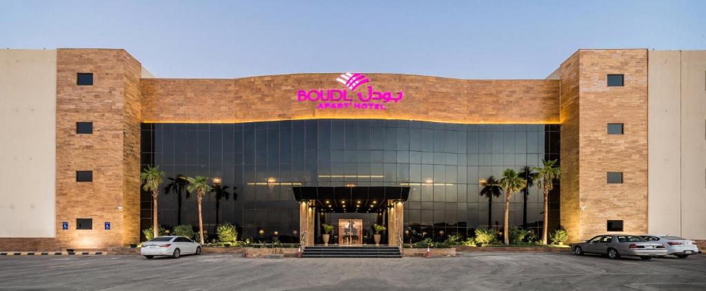 a large building with cars parked in a parking lot at Boudl Al Munsiyah in Riyadh