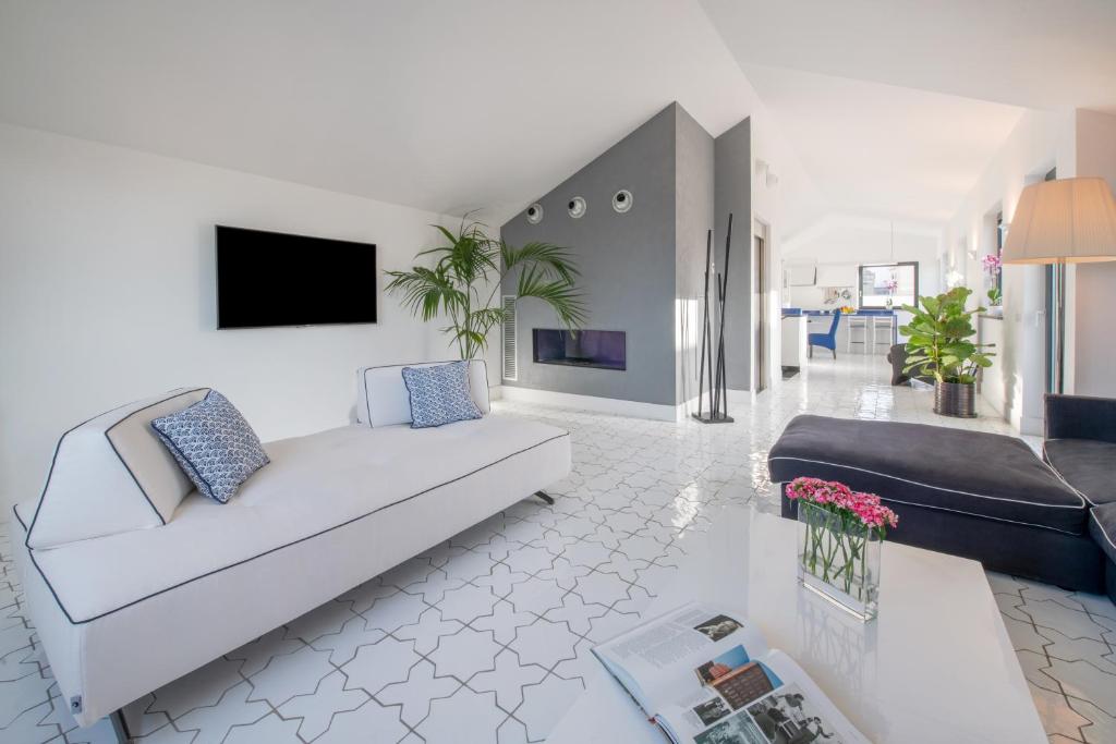 sala de estar con sofá blanco y TV en Luxury Apartment with Penthouse and Pool, en Sant'Agnello