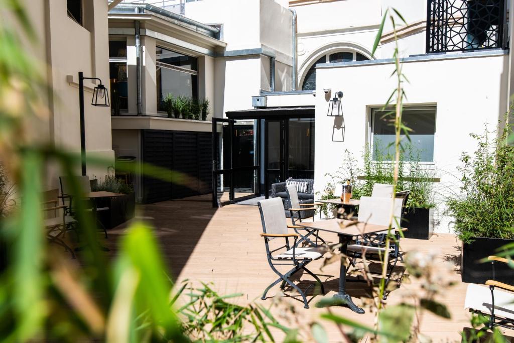 un patio con tavolo e sedie in un edificio di Continental Hotel a Reims