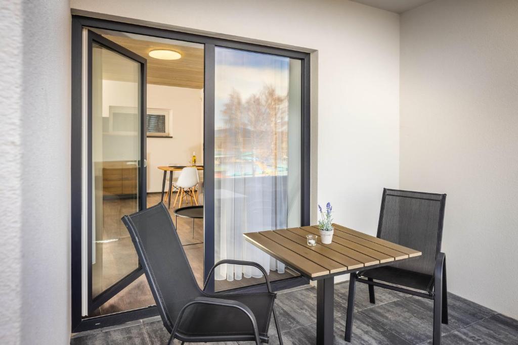 a dining room with a wooden table and chairs at Apartmány Panelka Costa Plana Lipno in Černá v Pošumaví
