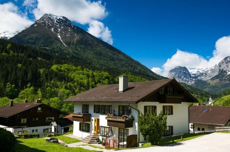 een wit huis met een berg op de achtergrond bij Haus am Forstamt 11 Ferienwohnungen in Ramsau