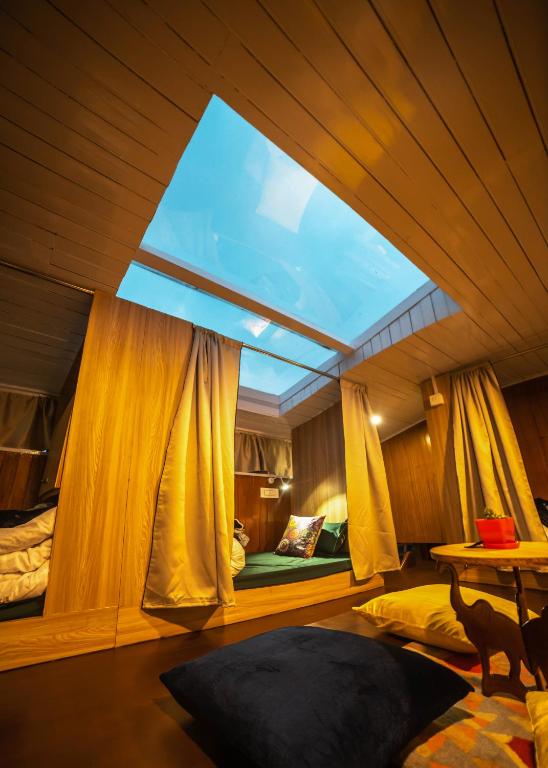 a room with a large window and two beds at Tag Along 2 0 Hostel Gangtok in Gangtok