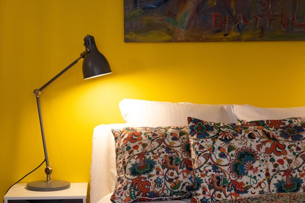 a yellow bedroom with a bed with a lamp and a pillow at Le Studio Gab&#39;s - Coup de coeur déco tout confort in Caluire-et-Cuire