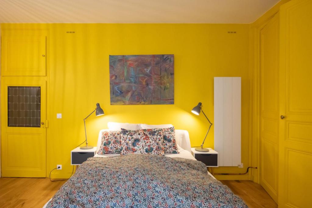 a yellow bedroom with a bed and two lamps at Le Studio Gab&#39;s - Coup de coeur déco tout confort in Caluire-et-Cuire