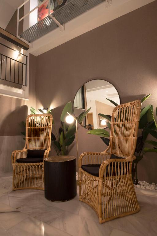 two wicker chairs and a mirror in a room at Goodnight Cádiz Apartments in Cádiz