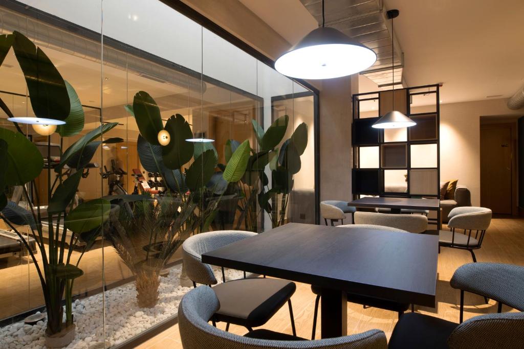 a meeting room with a table and chairs and plants at Goodnight Cádiz Apartments in Cádiz