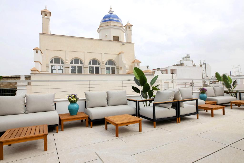 a row of couches and tables on a roof at Goodnight Cádiz Apartments in Cádiz