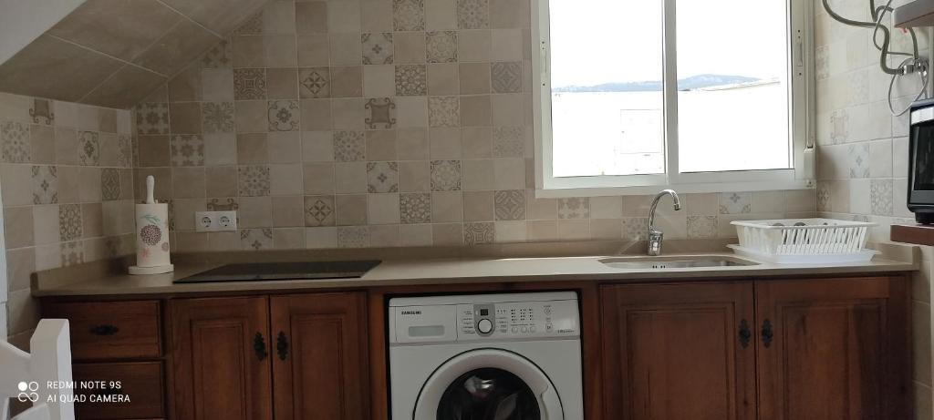 a kitchen with a washing machine and a sink at Apartamentos Bolonia - M a n u e l a in Bolonia