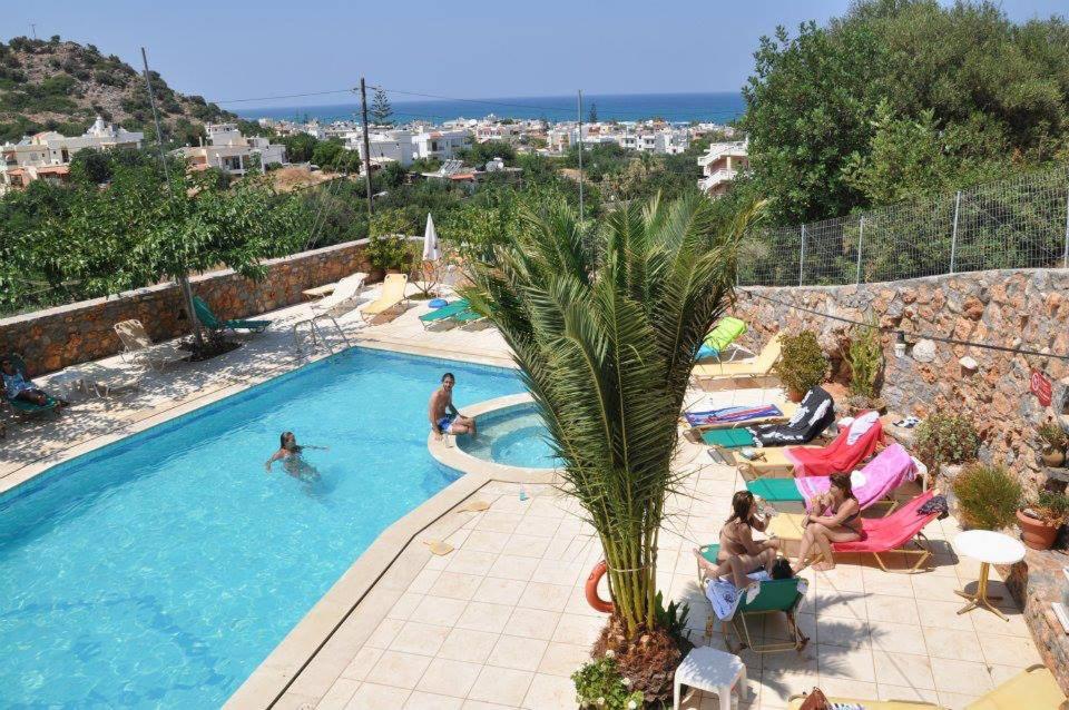 a swimming pool with people in a resort at Mary Sofi Residences by Estia in Stalida