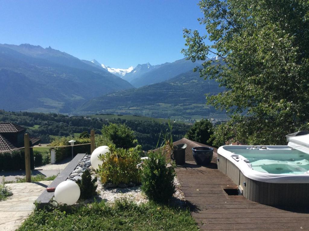 a backyard with a hot tub and a view of mountains at Chez Philippe in Savièse