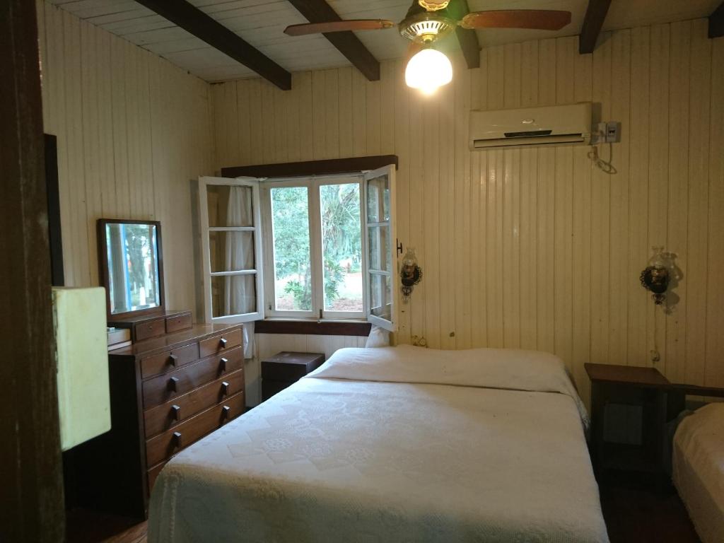 um quarto com uma cama branca e uma janela em Estancia las Mercedes em Eldorado