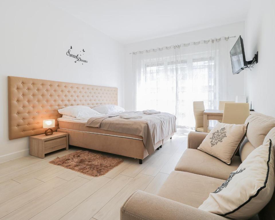 a bedroom with a bed and a couch at Aquamarina by Baltic Home in Świnoujście