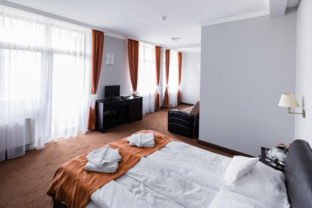 een hotelkamer met een bed met handdoeken erop bij HOTEL OPAL Zalau in Zalău