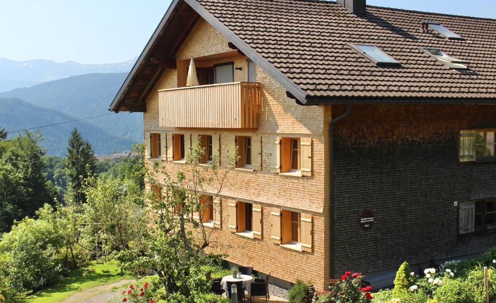 ein Gebäude mit einem Balkon auf der Seite in der Unterkunft WÄLDERHAUS Apartments in Schwarzenberg im Bregenzerwald