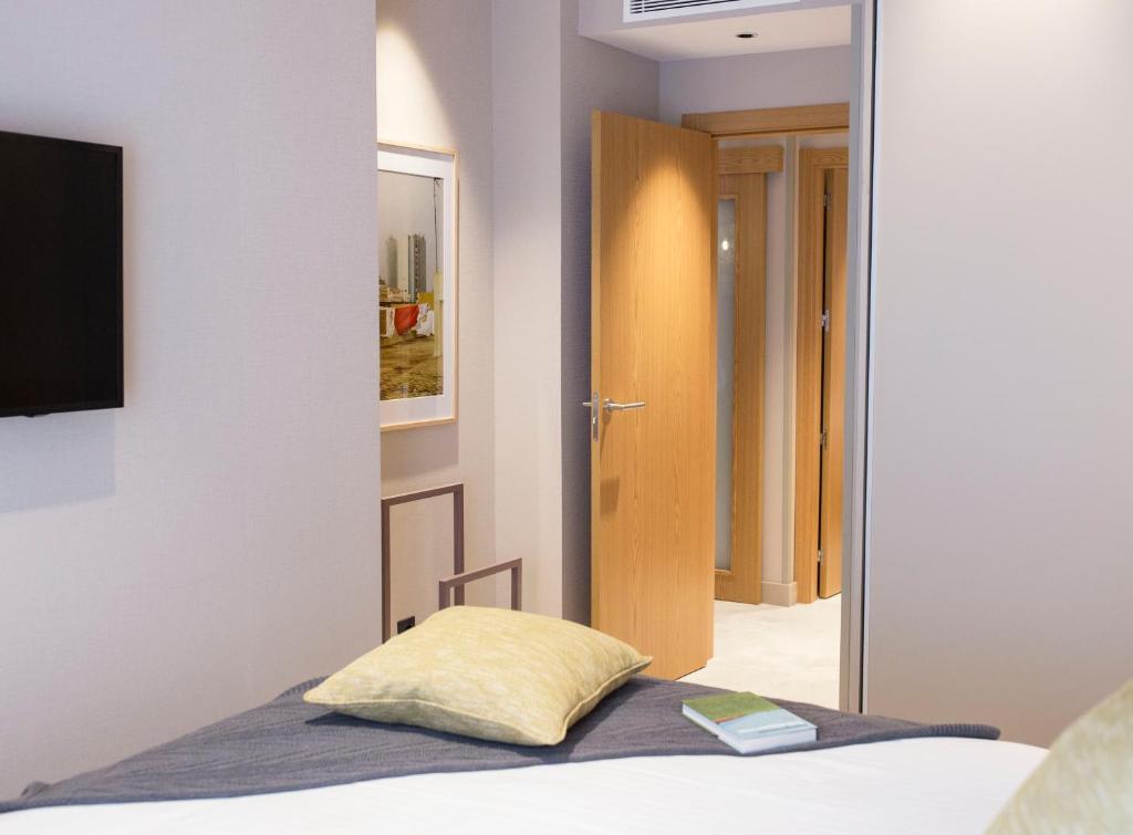 a bedroom with a bed with a yellow pillow at Goodnight Cádiz Apartments in Cádiz