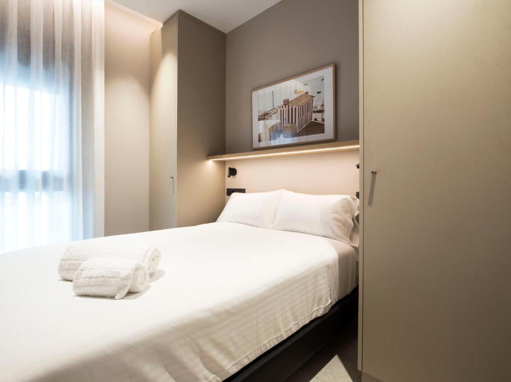 a bedroom with a white bed and a window at Goodnight Cádiz Apartments in Cádiz