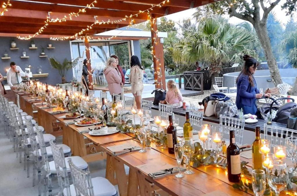 uma mesa longa com velas e garrafas de vinho em Misty Mountain Reserve em Stormsrivier