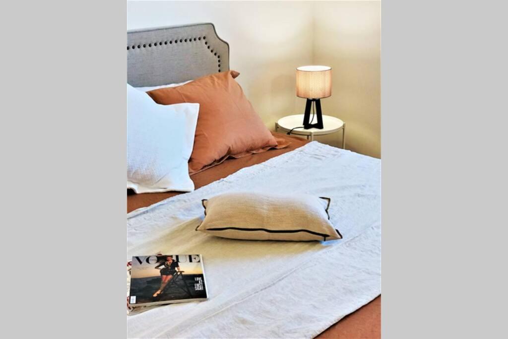 Una cama con almohada y una revista. en Luxus P4T Family 3 bedroom with SAUNA, en Brindisi
