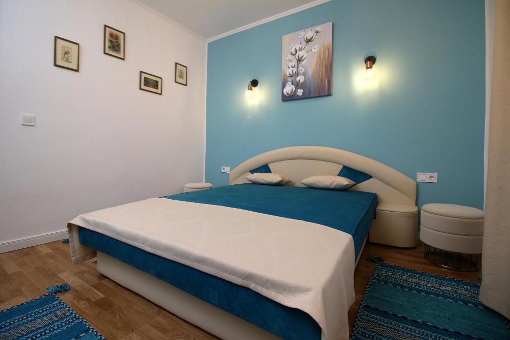 a bedroom with a bed and a blue wall at White Stone in Sibiu