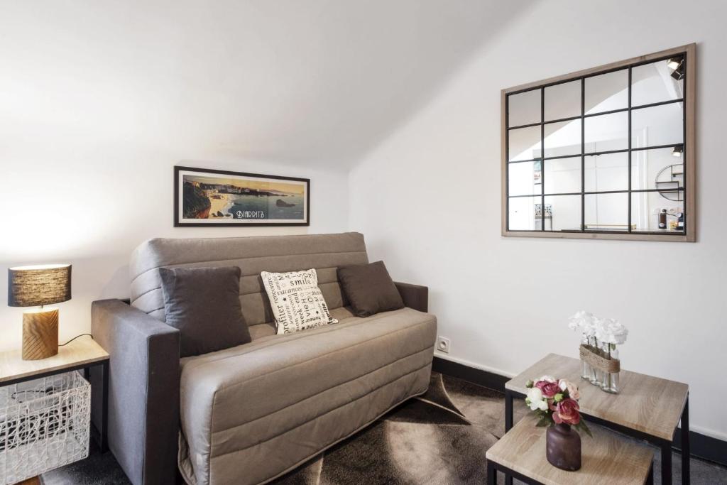 un salon avec un canapé et une fenêtre dans l'établissement Studio Labordette - Welkeys, à Biarritz