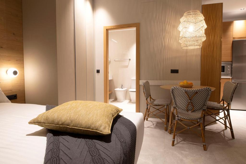 a bedroom with a bed and a table and chairs at Goodnight Cádiz Apartments in Cádiz
