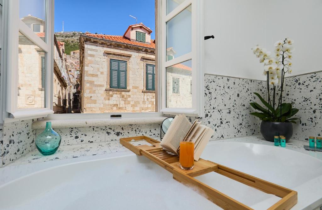 a bathroom with a bath tub with a window at Bota Palace in Dubrovnik
