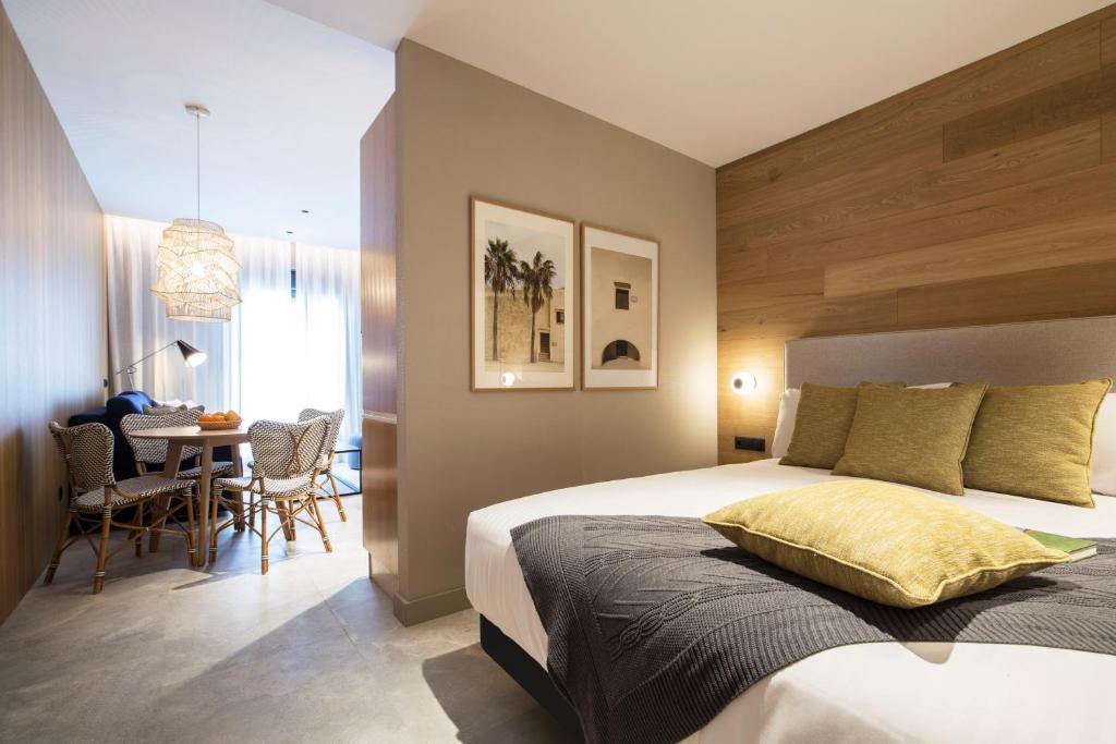 a bedroom with a bed and a table with chairs at Goodnight Cádiz Apartments in Cádiz