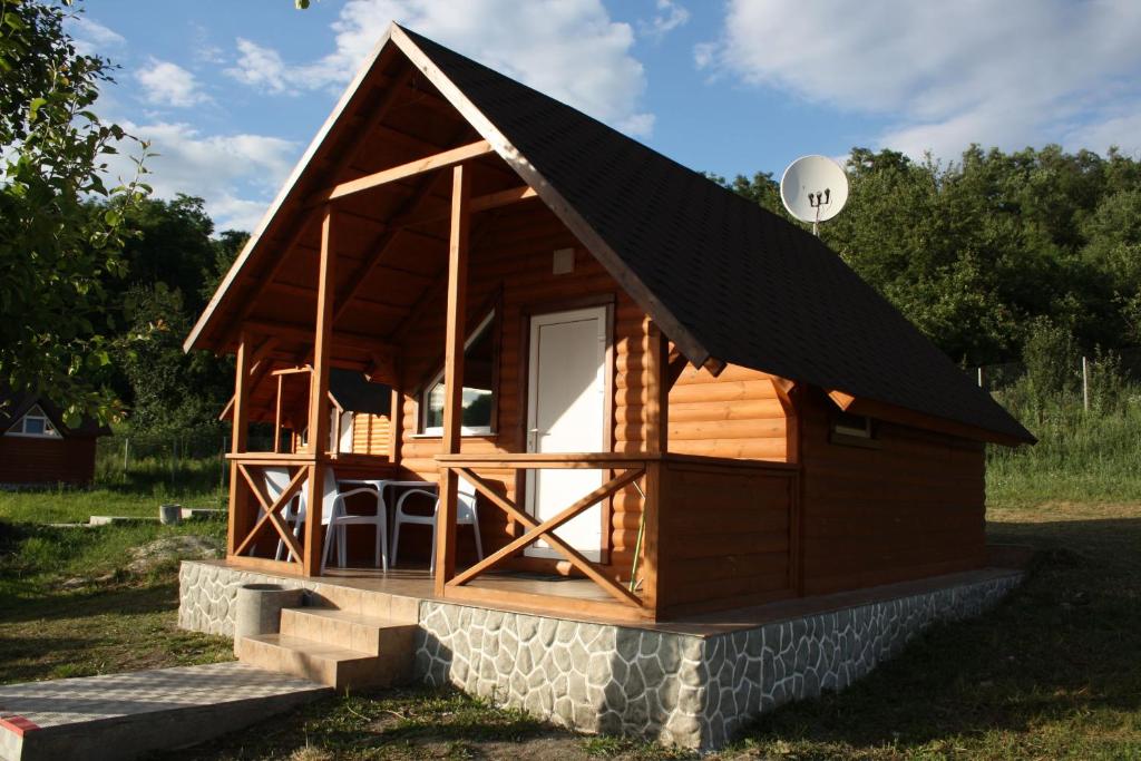 een blokhut met een schuin dak en een veranda bij Шафран in Krasnaya Slobodka