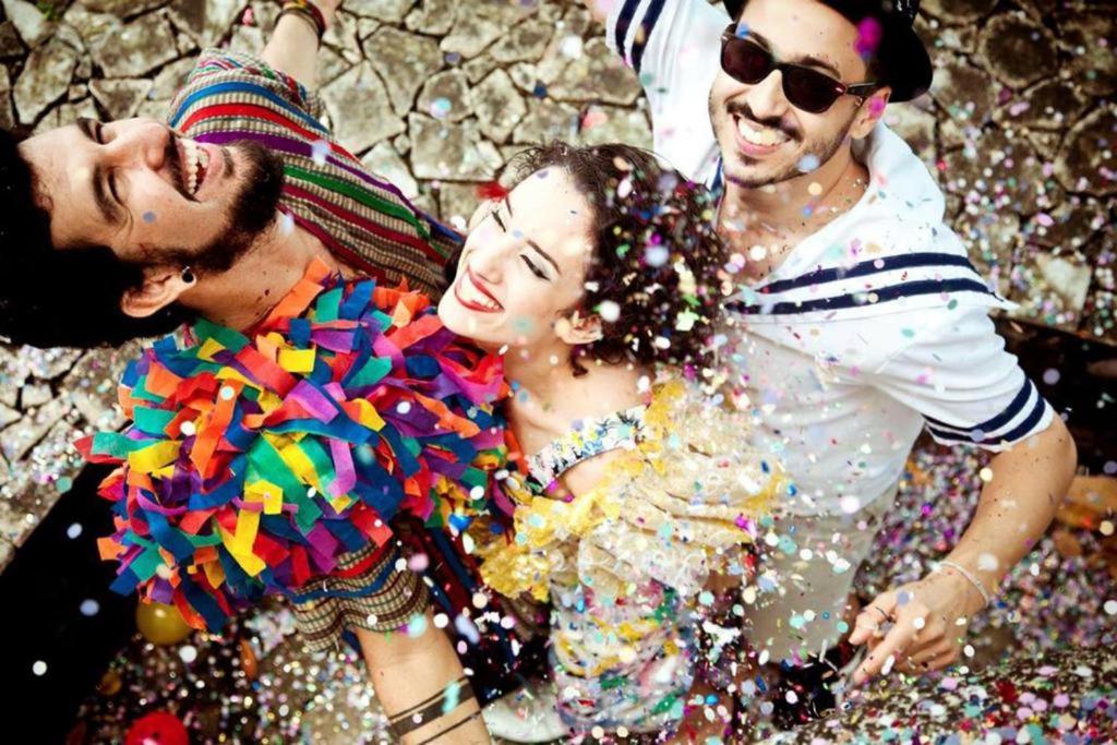 a group of people posing for a picture with confetti at Carnaval Inn Salvador in Salvador