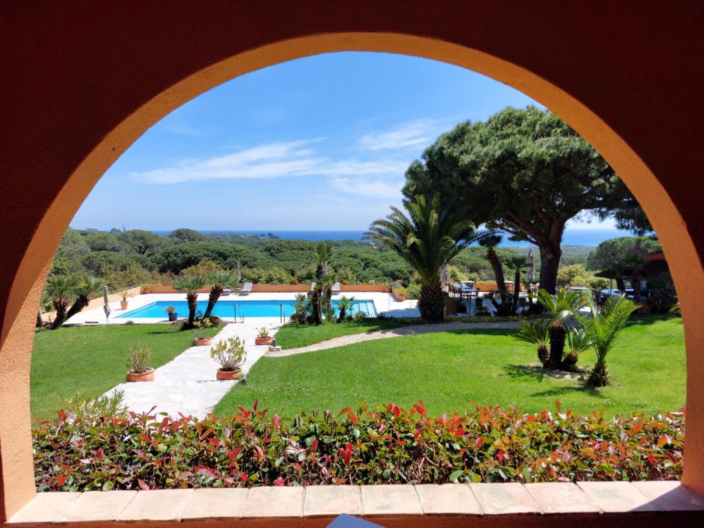 a view of a pool from an archway in a resort at Hôtel les Bouis - Vue mer in Saint-Tropez