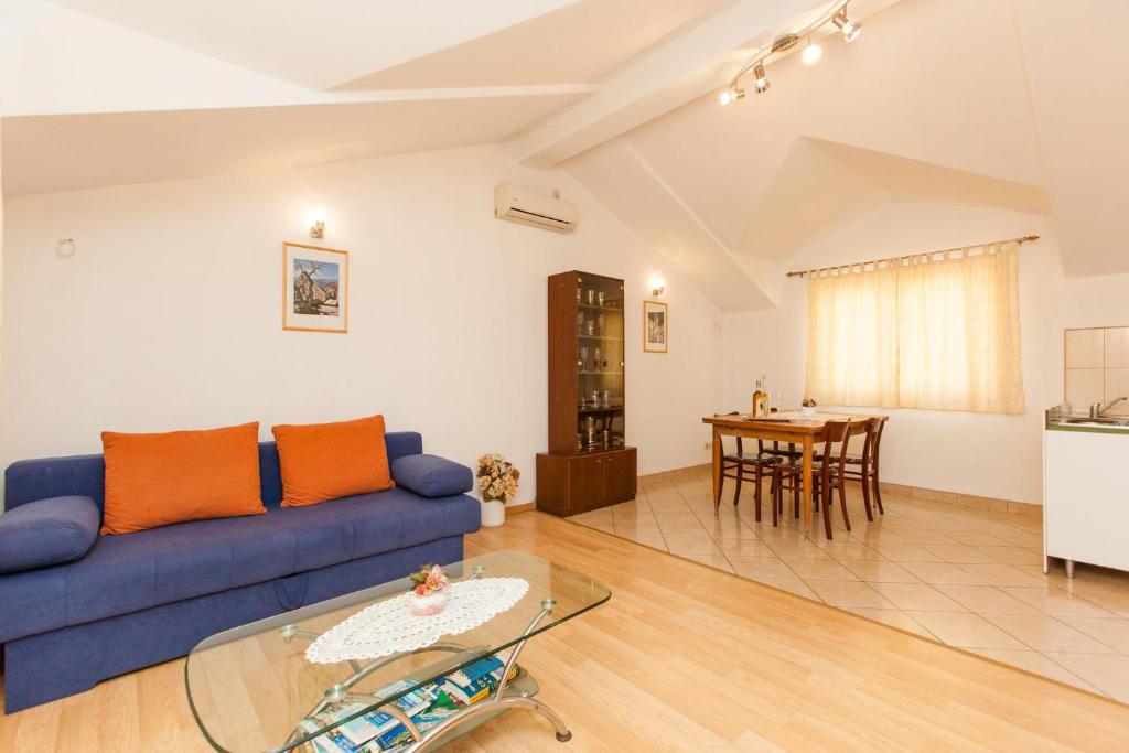 ein Wohnzimmer mit einem blauen Sofa und einem Tisch in der Unterkunft Holiday Home Beata in Trogir
