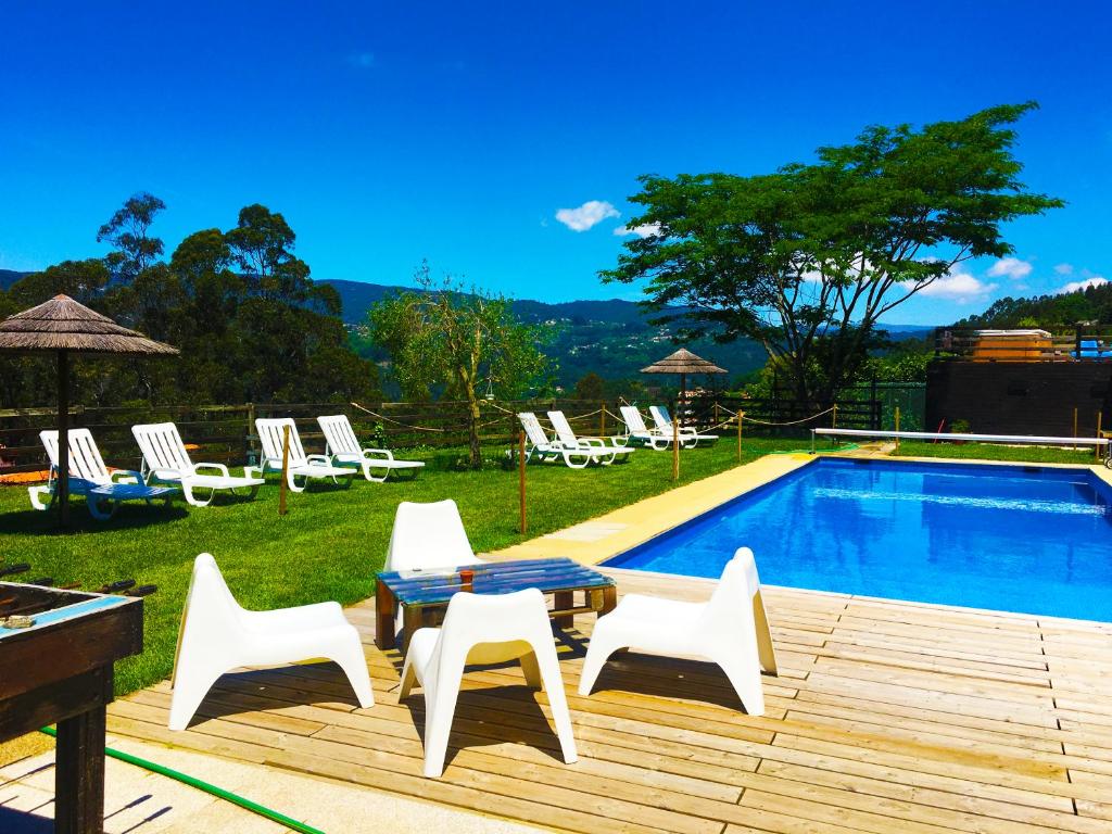 a patio with a table and chairs next to a pool at Villa de Paco in Sever do Vouga