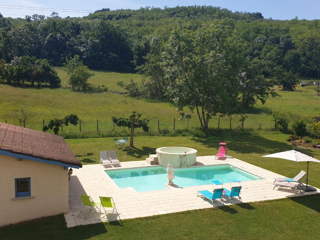 an outdoor swimming pool with chairs and a house at Chambres et Table d'hôtes "La Pastorale Gourmande" FR - NE - EN - DE - IT in Marcollin