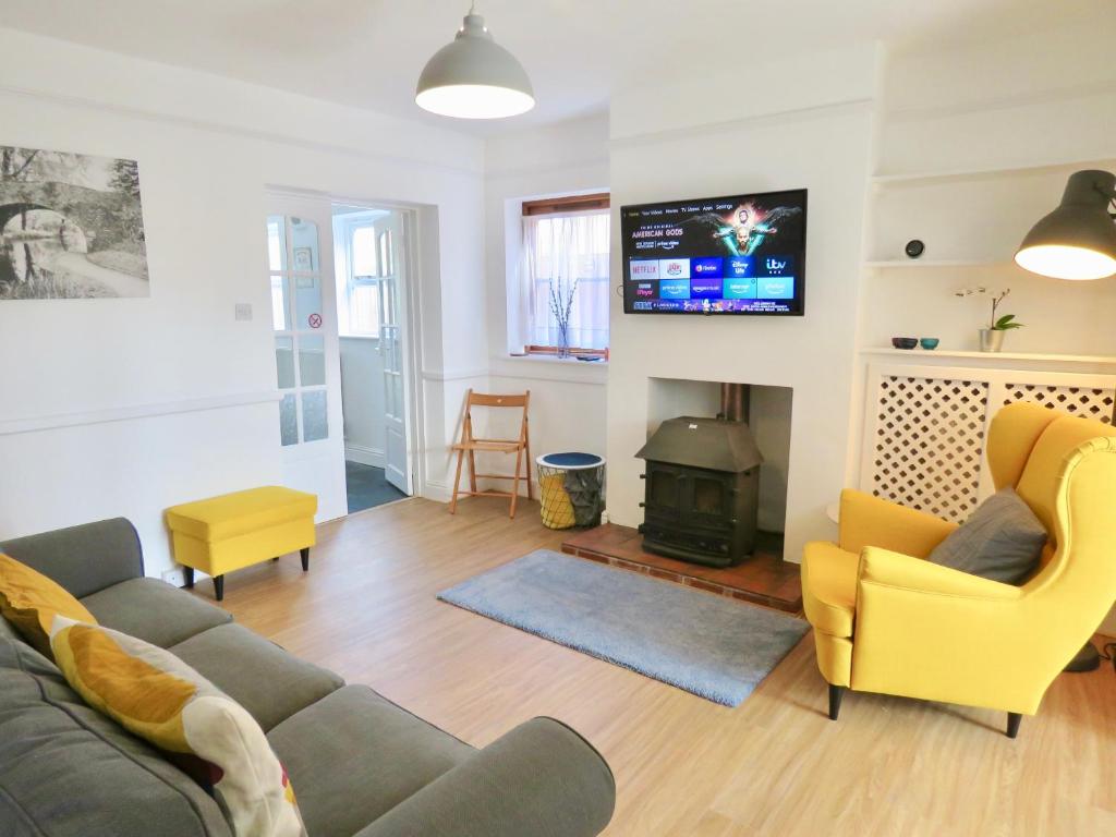 uma sala de estar com um sofá e uma lareira em Lyndale House - Exclusive use, self catering, fpventures Stroud em Stroud