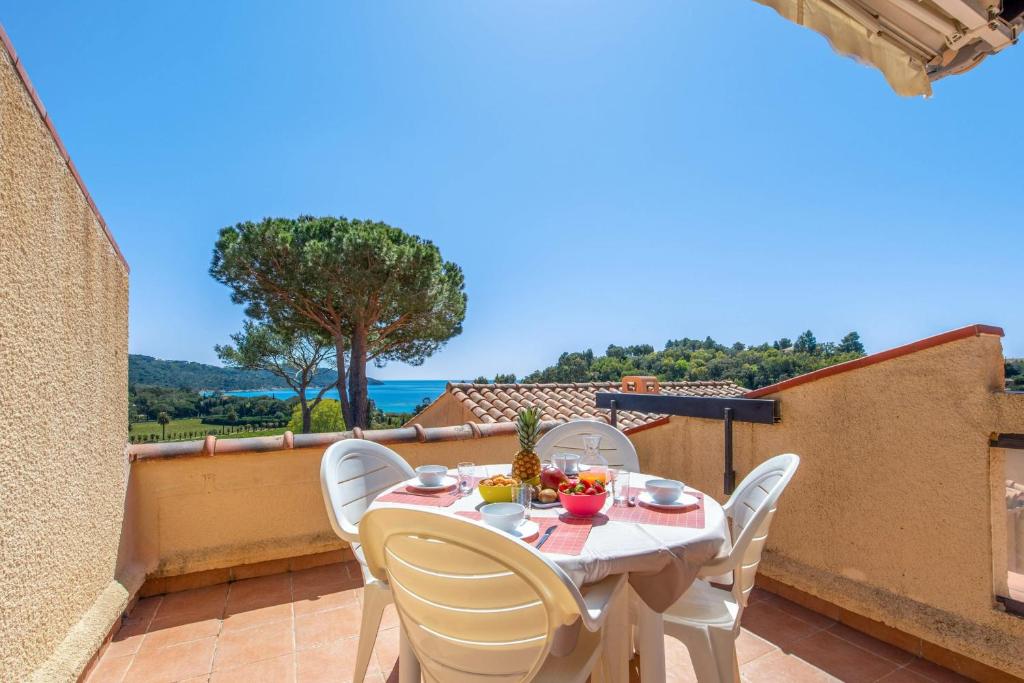 een tafel en stoelen op een balkon met uitzicht bij Nice flat at 8 min walk from the beach in La Croix-Valmer - Welkeys in La Croix-Valmer