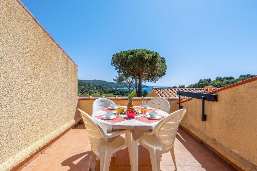 une table et des chaises sur le balcon d'une maison dans l'établissement Appartement Moorea - Welkeys, à La Croix-Valmer
