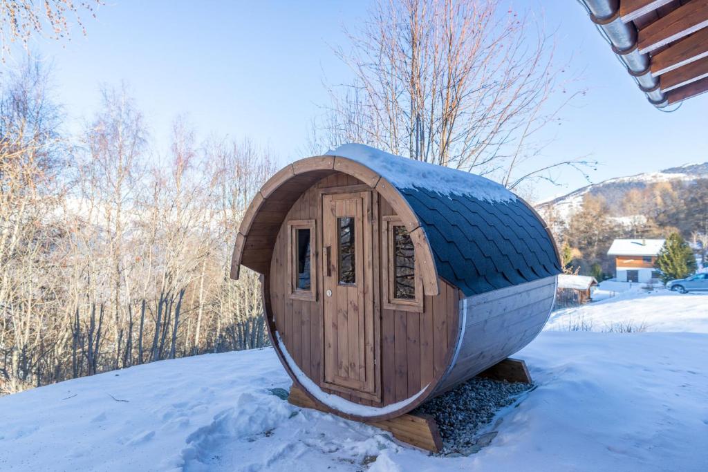 ein kleines Holzhundehaus im Schnee in der Unterkunft Chalet Pierre Blanche in Nendaz