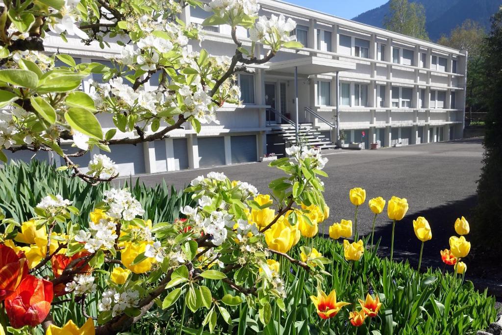 ein Gebäude mit vielen Blumen davor in der Unterkunft Hôtellerie Franciscaine in Saint-Maurice