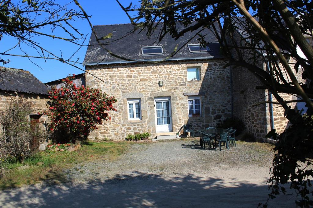 una casa de piedra con una mesa y sillas delante de ella en Gite LA ROCHERIE, en Hambers