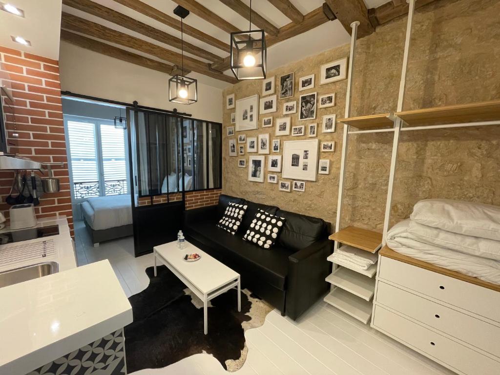 una sala de estar con un sofá y una cama en Appartement Aix, Neuf tout équipé, en París