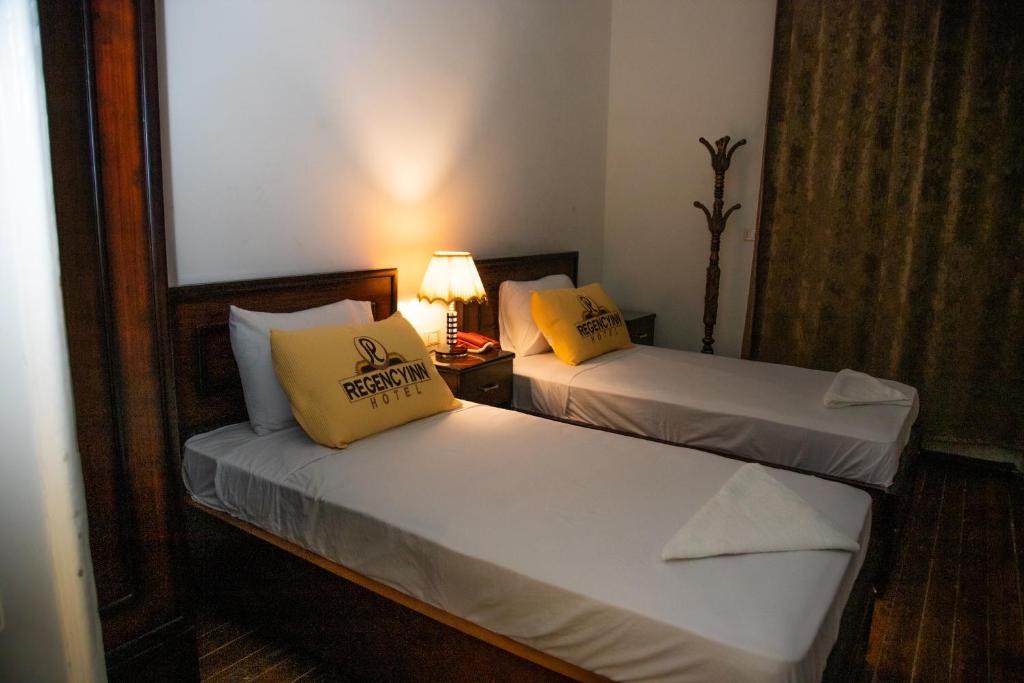 A bed or beds in a room at Regency inn