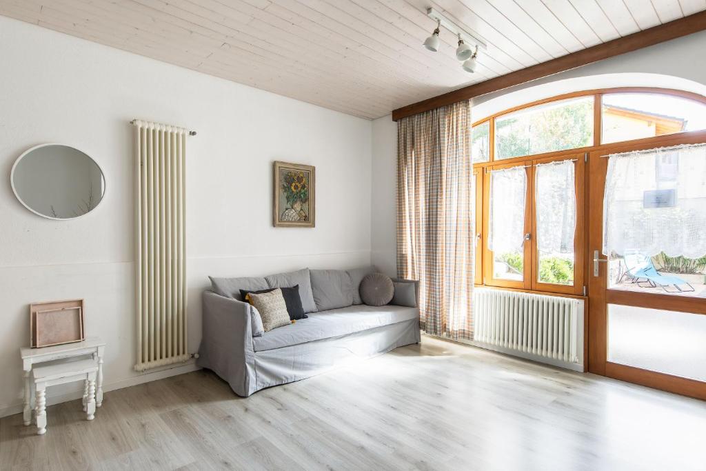 - un salon avec un canapé et une fenêtre dans l'établissement Rose Apartment by Quokka 360 - refined two-bedroom apartment with garden, à Lugano