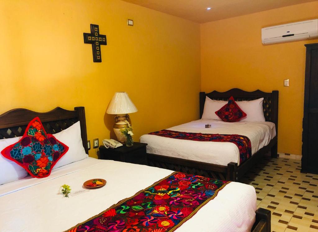 um quarto com duas camas e uma cruz na parede em Camino Mexicano Hotel & Resort em Tuxtla Gutiérrez