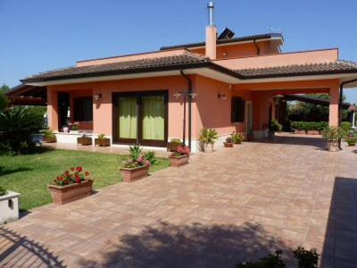 dom z ceglanym patio przed nim w obiekcie La stanza delle Muse in Villa con Piscina w mieście Fontane Bianche